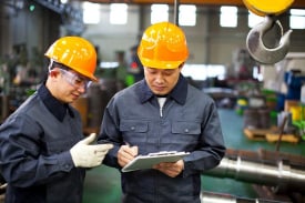 Inspector using tools to check electronic parts